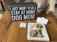 Lot including the wooden dog mom sign and the Willow Tree Hug figurine on a wooden surface.