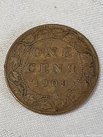 Close-up image of the reverse side of the 1909 Canada large one cent penny coin showing the 'ONE CENT 1909' inscription surrounded by maple leaf design.