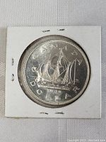 Front side of the 1949 Canadian silver dollar coin showing the Bluenose schooner sailing with detailed rigging and the inscriptions 'CANADA DOLLAR 1949' and 'FLORANT TERRA NOVA'.