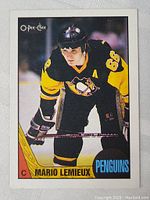 Front of 1987-88 OPC Mario Lemieux hockey card showing player in Penguins uniform.