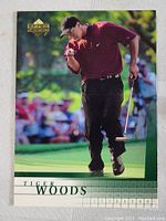 Full front view of the 2001 Upper Deck Tiger Woods rookie card showing the golfer on the green with surrounding crowd blurred.