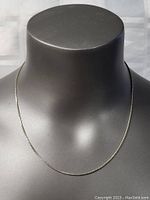 Full view of the 18 inch sterling silver box chain necklace displayed on a black mannequin bust showing length and shine.