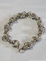 Top down view of the sterling silver bracelet showing the intertwined circular chain links with crystal beads and the spring ring clasp