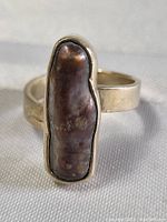 Close-up front view of sterling silver ring with raw fire agate stone showing the irregular shape and natural texture of the stone