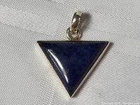 Front view of triangular lapis lazuli pendant set in sterling silver with silver bail.
