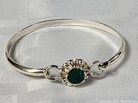 Full view of sterling silver malachite bracelet showcasing the smooth silver band and central stone.