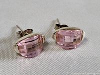 Close-up photo of the front view of the sterling silver pink topaz earrings displaying the checkerboard cut pink gemstones.