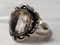 Close-up angled view of the pear-shaped smokey topaz ring showing the detailed scalloped silver setting and faceted stone.