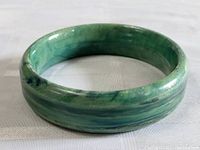 Front view of the vintage jade tone Bakelite bangle bracelet showing color, form, and surface wear.