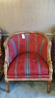 Front view of the vintage arm chair showing detailed wood frame and red upholstery with vertical grey stripes and damask pattern.