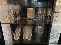 Full display showing all glassware and ice buckets in shelving unit.