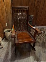 Front view of rocking chair showing full structure, carved back and seat