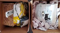Two cardboard boxes showing serger, iron, manual and electric scissors packed with paper