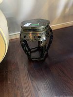 Side view of the painted side table showing intricate cut-out patterns and gold detailing