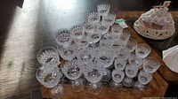 Top-down view of the 32 piece Tudor Galaxy stemware set arranged in groups showing detailed cut crystal pattern on all glasses.