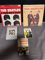 Photo showing original motion picture soundtrack album, a Beatles introduction album, Beatles paperback books, and collectors DVD arranged on a flat surface.