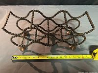 Side view of the bike chain wine rack with a measuring tape showing length about 15 inches