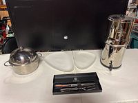 Overview of lot on table: domed pot, two white triangular serving trays, coffee urn, and Towle carving set in box.