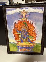 Full view of framed Mahakala Tibetan art with intricate flame and deity details under glass.