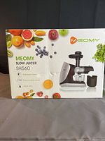 Box of Meomy Slow Juicer SH560 with colorful fruit graphics and product image on front.