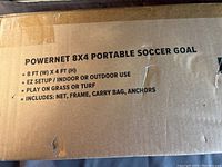 Box top view showing product name, dimensions 8 ft by 4 ft, setup details, and included items: net, frame, carry bag, and anchors