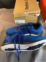 Reebok ZPrint Run shoes side view showing mesh upper, blue laces, white and black sole, with Reebok box in background