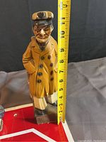 Wooden vintage sea captain statue with a measuring tape showing height at about 9 inches.