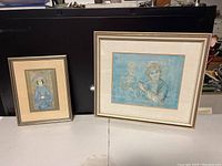 Photo showing both framed lithographs, one smaller of an Asian woman and one larger titled The Flutist with a flute player and another figure in the background.