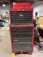 Front view of red two-piece Craftsman rolling tool chest showing top box and bottom cabinet on casters
