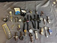 All items displayed together on a gray surface showing full assortment including watches and jewelry.