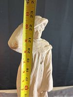 Measurement tape held against the statue showing height is approximately 21 inches.