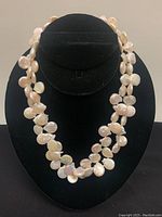 Full front view of the double-strand fresh water coin pearl choker on black display stand showcasing the overall style and design.