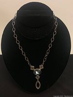 Full view of the 925 silver necklace with pendant displayed against a black bust stand.