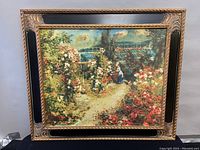 Full view of the ornate black and gold framed embossed print depicting a garden with flowers and two women near a greenhouse.