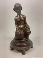Front view of bronze nude footed sculpture showing seated female figure with detailed facial features and hair style.