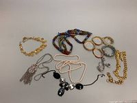 Full view of the costume jewelry lot showing all necklaces, bangles, and bracelets in the set.