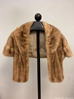 Vintage ladies mink fur stole displayed on a mannequin stand showing front and sleeve details.
