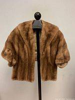 Front view of vintage brown mink fur stole on a mannequin showing short sleeves and overall plush fur texture.