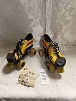 Pair of vintage roller skates with yellow, red, and black design, size 7, shown with instruction paper.