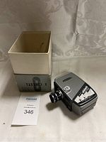 Yashica 8 vintage film camera shown with original box, camera positioned front angled showing lens and control dial.