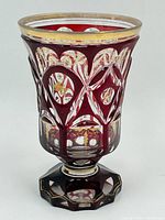 Front view of cranberry glass centerpiece showing gold gilt rim and detailed cut patterns with facets.