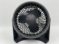 Front view of a black Honeywell desk fan showing circular protective grill and three blades with Honeywell logo at center hub.