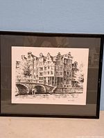Full image of the framed pen drawing showing Amsterdam canal houses and bridged canal