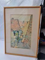 Full image of framed watercolor showing European town rooftops, passage, balcony and plants