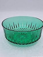 Side view of the green depression glass bowl showing detailed pressed starburst and diamond pattern design.