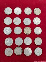 View of all 20 Canadian silver dimes arranged on red background showing front and back sides, varying wear and patina.