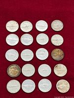 Twenty Canadian silver dimes arranged on red background showing obverse and reverse.