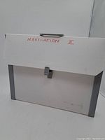 White plastic carrying case labeled 'Navigation II' with handle and clasp, showing signs of use and some wear.