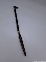Full length view of vintage wooden shoehorn showing overall shape and materials.