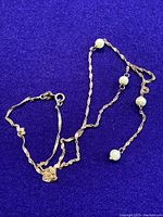 Photo of the necklace partially coiled, emphasizing the clasp and some pearls.